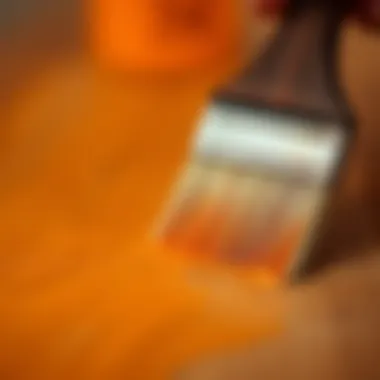 A close-up of a brush applying paint on a wooden surface