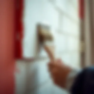 Brush applying lighter paint on a wall